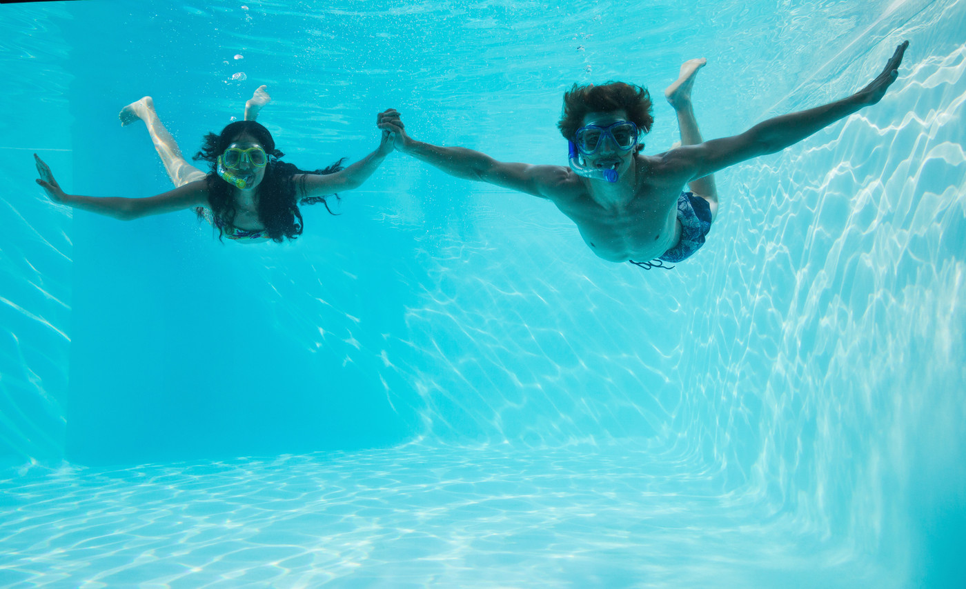 Couple wearing snorkels in swimming pool