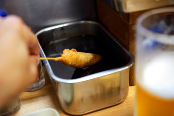 「元祖串かつ だるま 新世界総本店」料理 644500 串カツにたっぷりソースをつけて。