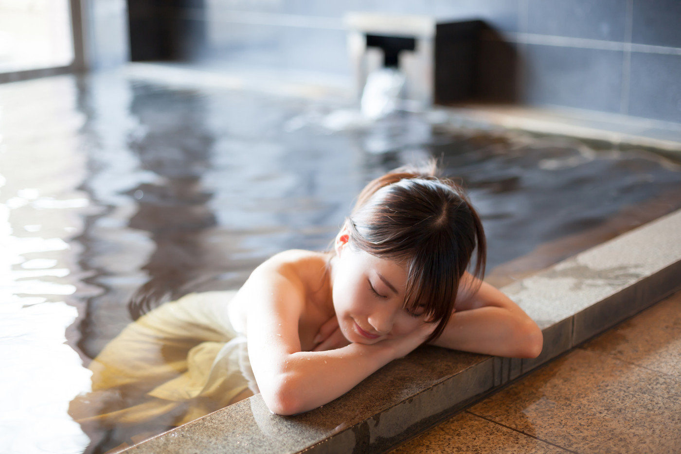 温泉に入りリラックスする可愛い女性