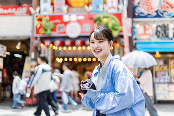 A camera girl taking pictures of the streets of Osaka