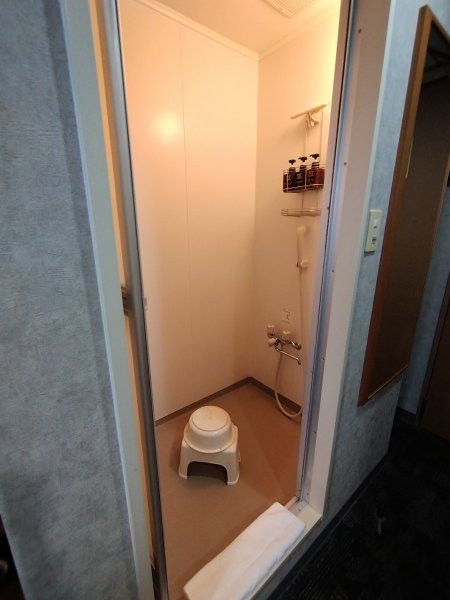 シャワールームに洗面器と椅子