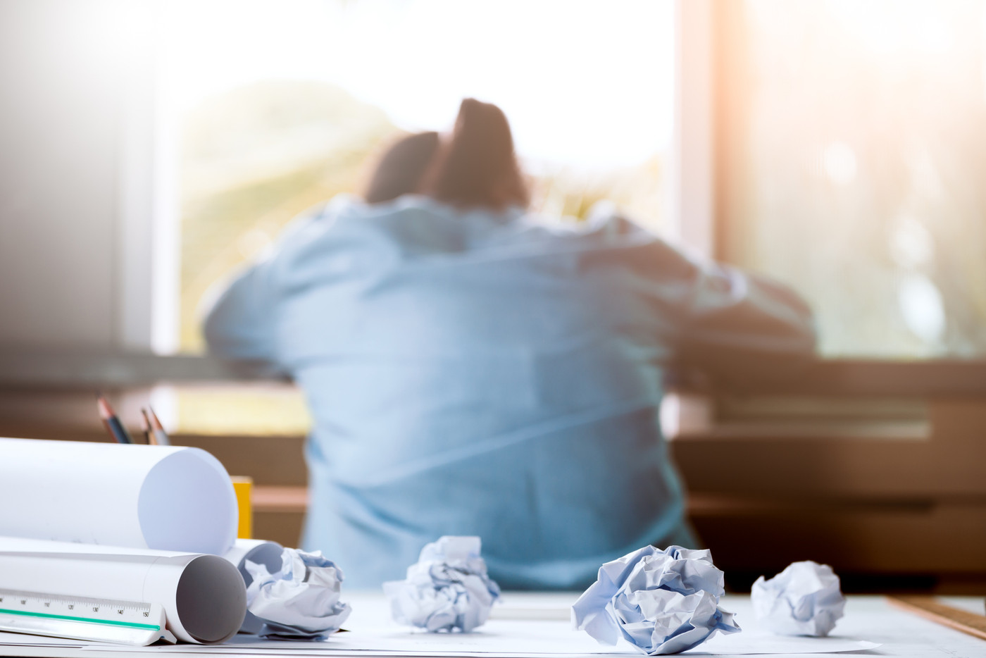 crumpled paper on table with unhappy businesswoman