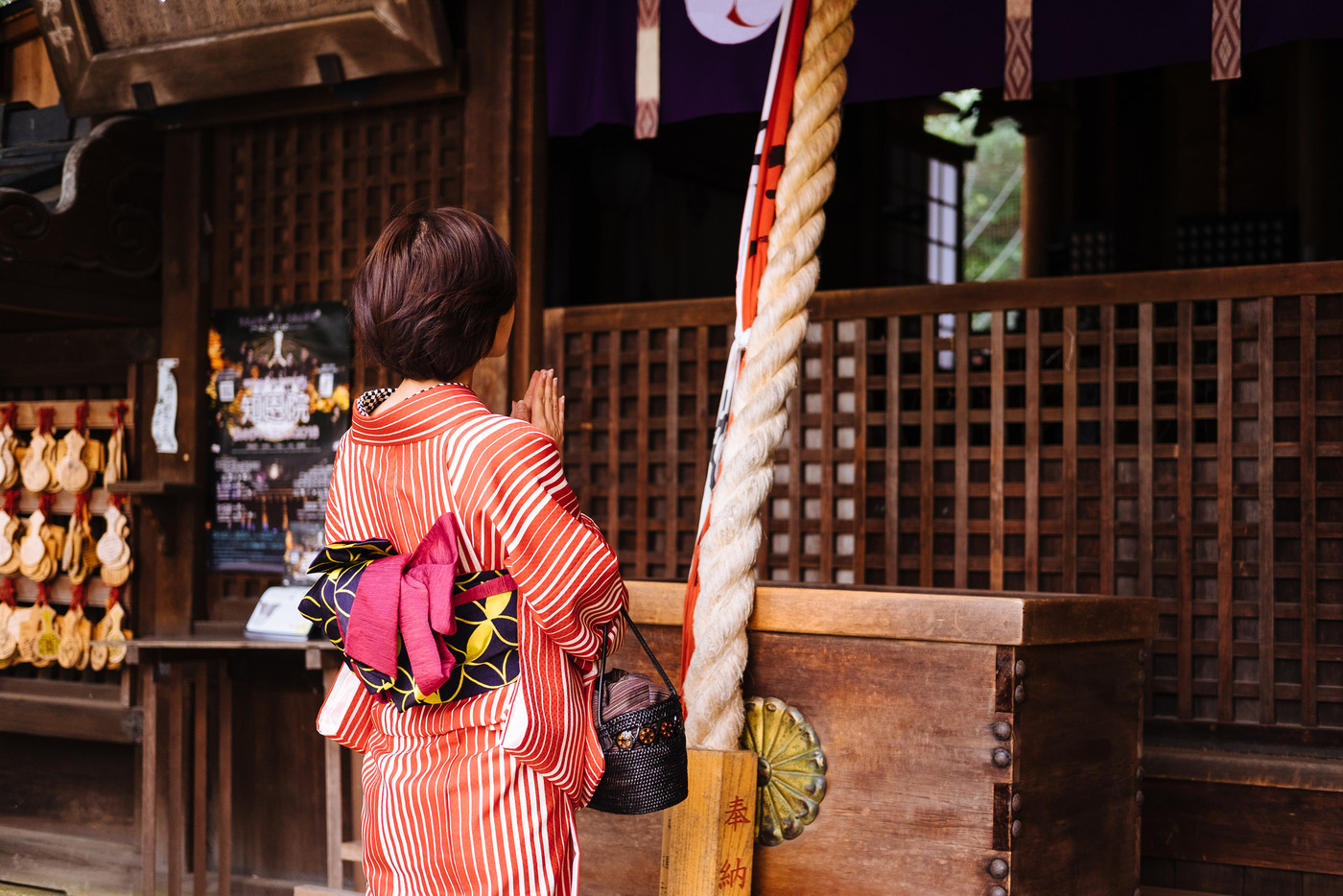 神社にお参りをする女性