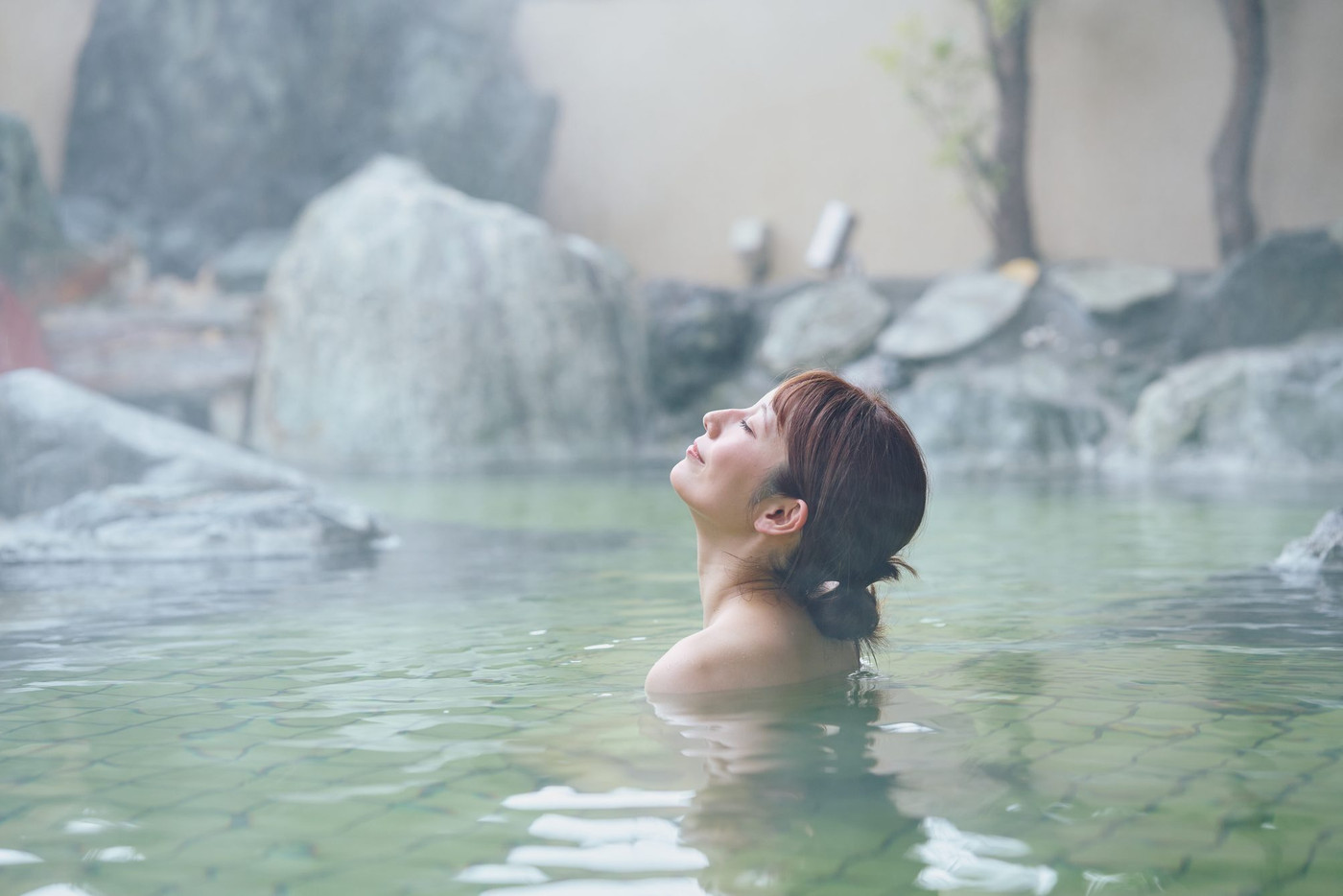 のんびり露天風呂に入る若い女性　撮影協力・白玉の湯 泉慶