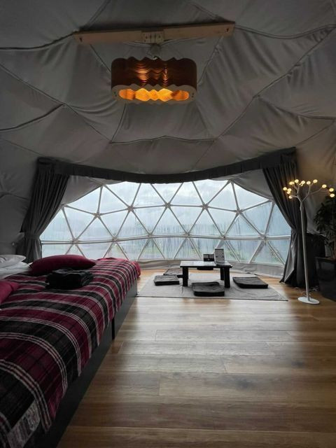 秘密基地のようなテント内は、約36㎡のゆったりとした広さ。セミダブルベット2台を備え、布団を敷いて4人まで宿泊できる。おしゃれな照明や「ヨギボー」のソファなど、リラックスアイテムも / 2