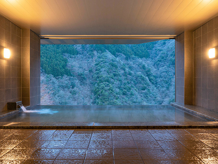 目の前に静かな森が広がる大浴場。専用のケーブルカーで向かう川沿いの露天風呂も人気です