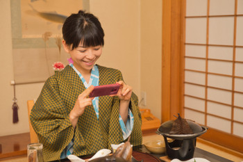 A woman taking pictures of meal at ryokan