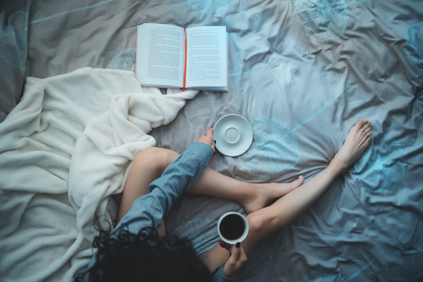 pretty brunette woman in morning bed with books and coffee