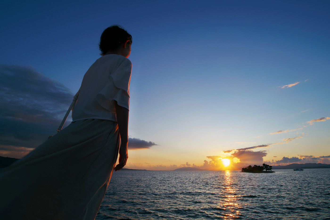 宍道湖の夕日を見つめる女性(島根県松江市)