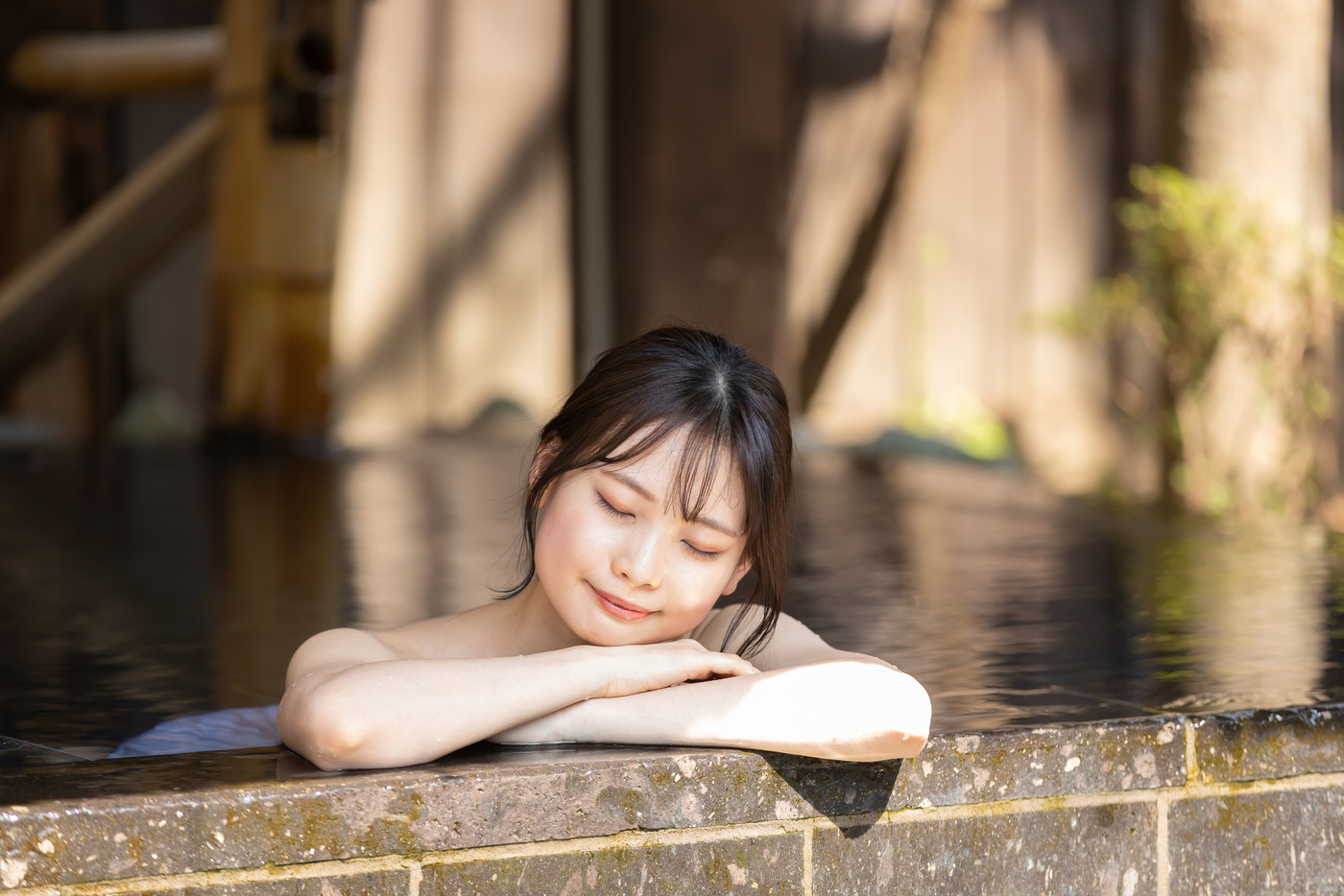 のんびり露天風呂に入る若い女性