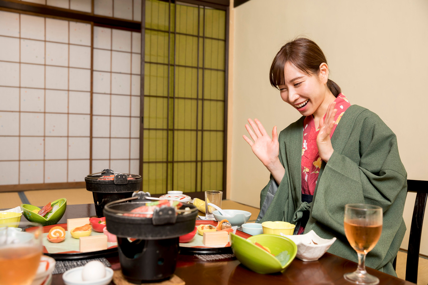 温泉旅館夕飯を見て喜ぶ若い女性