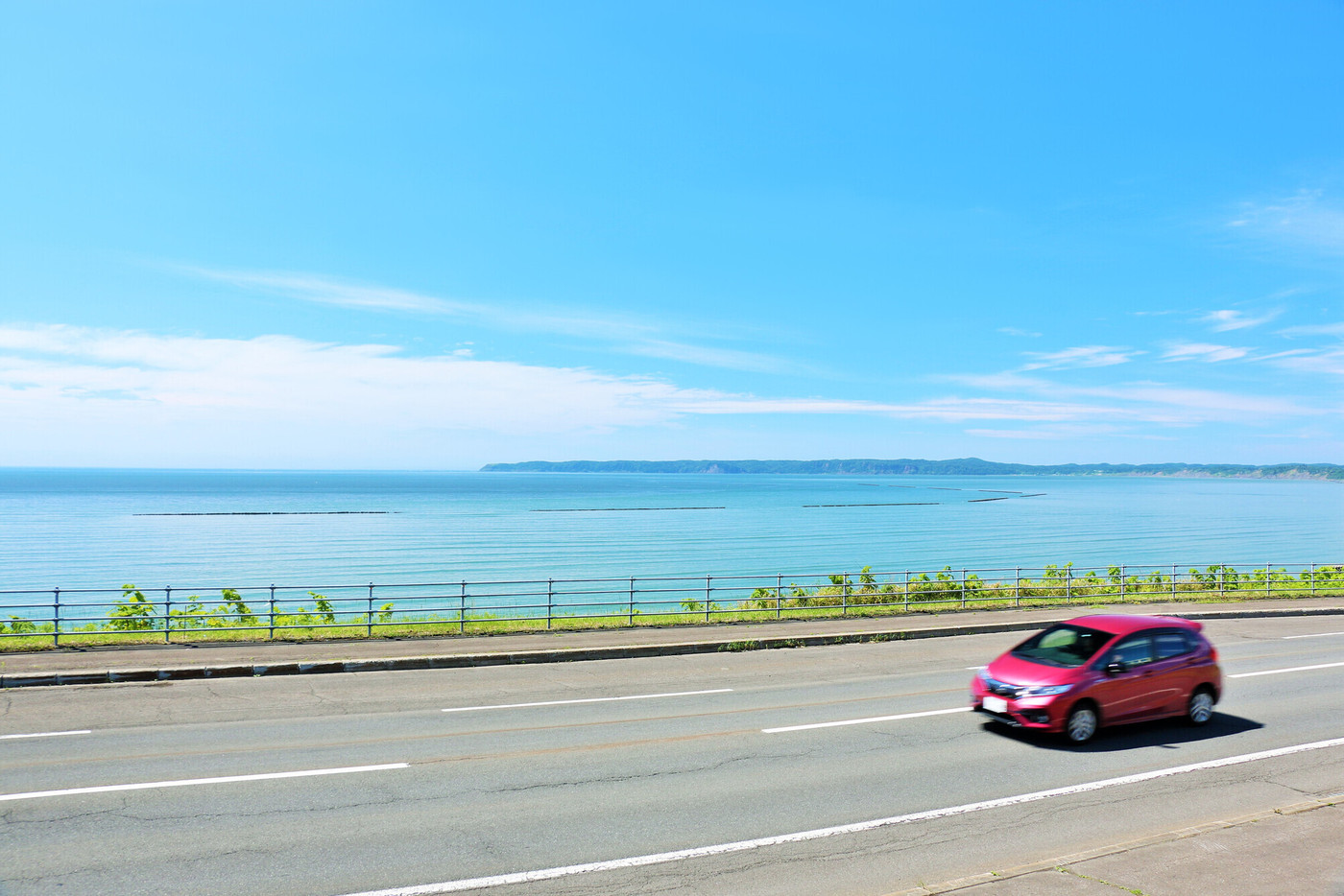 北海道　青空と海の道を走る車