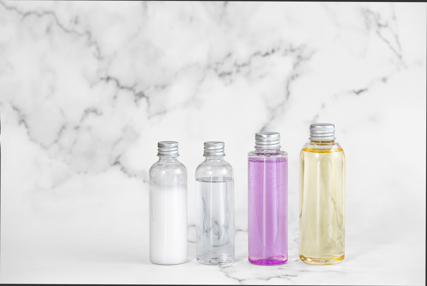 大理石を背景に並べたプラスチック製の化粧品ボトル