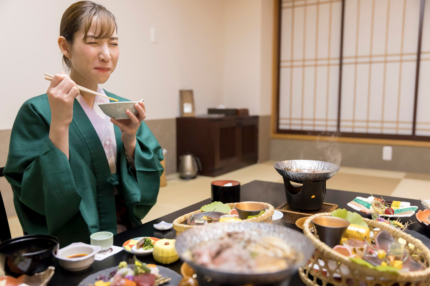 旅館の料理を食べてテンションが上がる若い女性　全国旅行支援