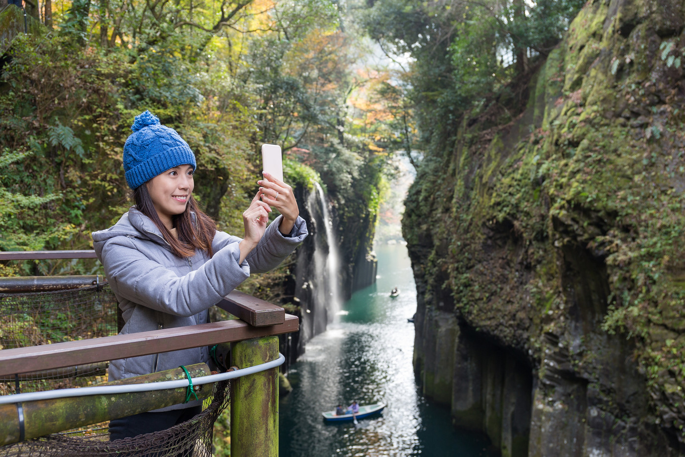Woman taking selfie by cellphone in Takachiho gorge
