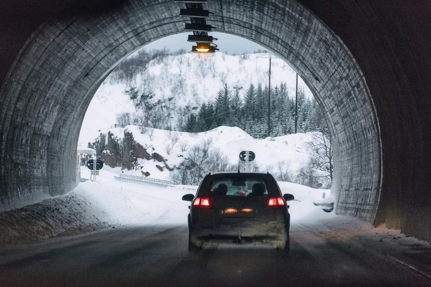 Rear car driving in mountain tunnel on winter