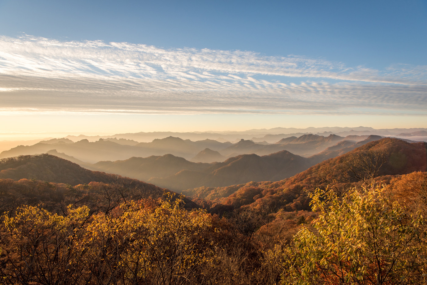 旧碓氷峠見晴台から望む妙義山方向の山並みと紅葉の樹林と朝日