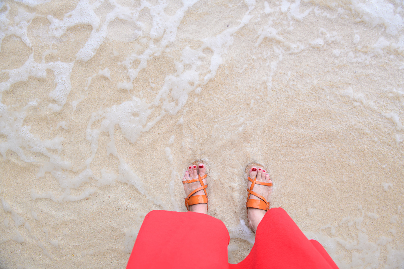 砂浜を歩く女性の足元