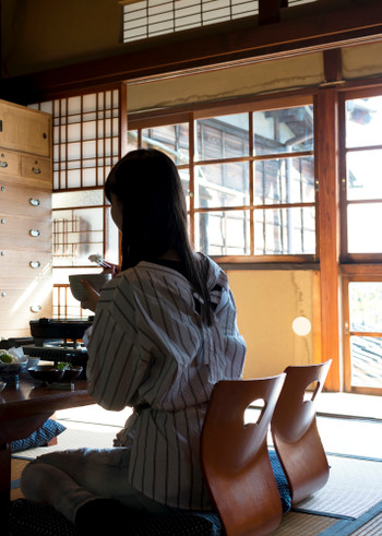 旅館で日本食を食べる若い女性
