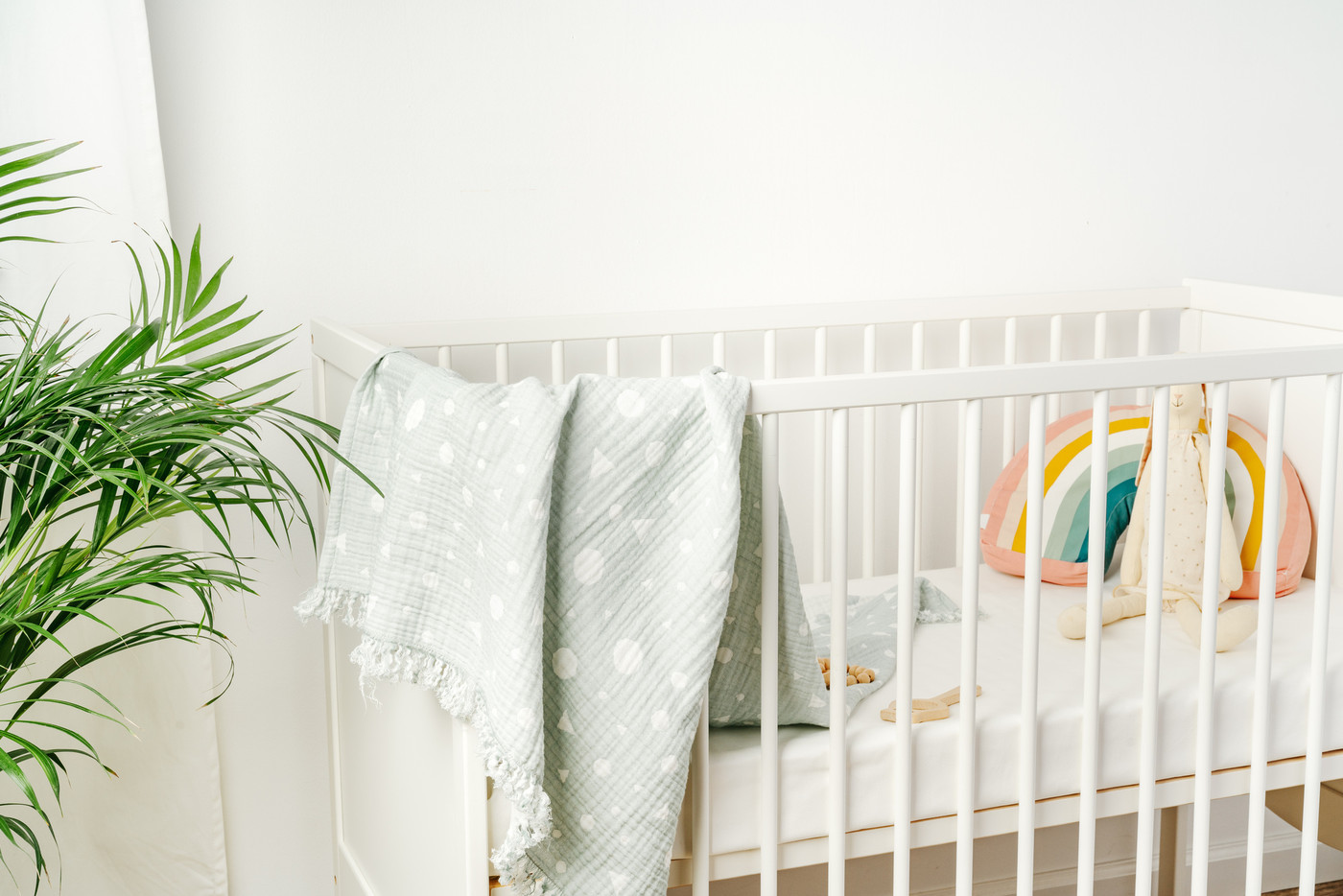 Muslin baby blanket hanging on child's bed in nursing room