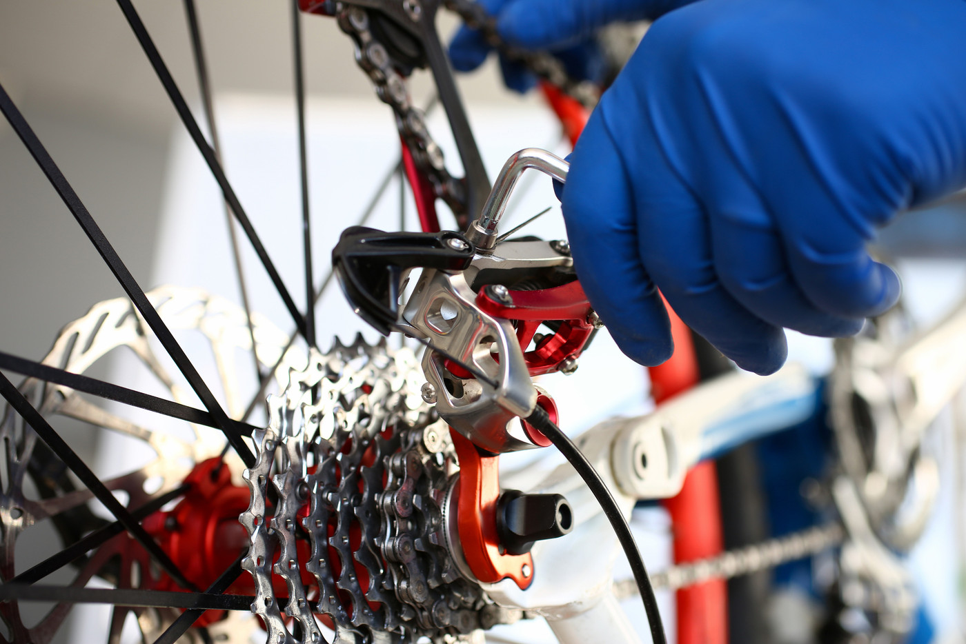 Gloved repairman hand adjusts tool on bicycle