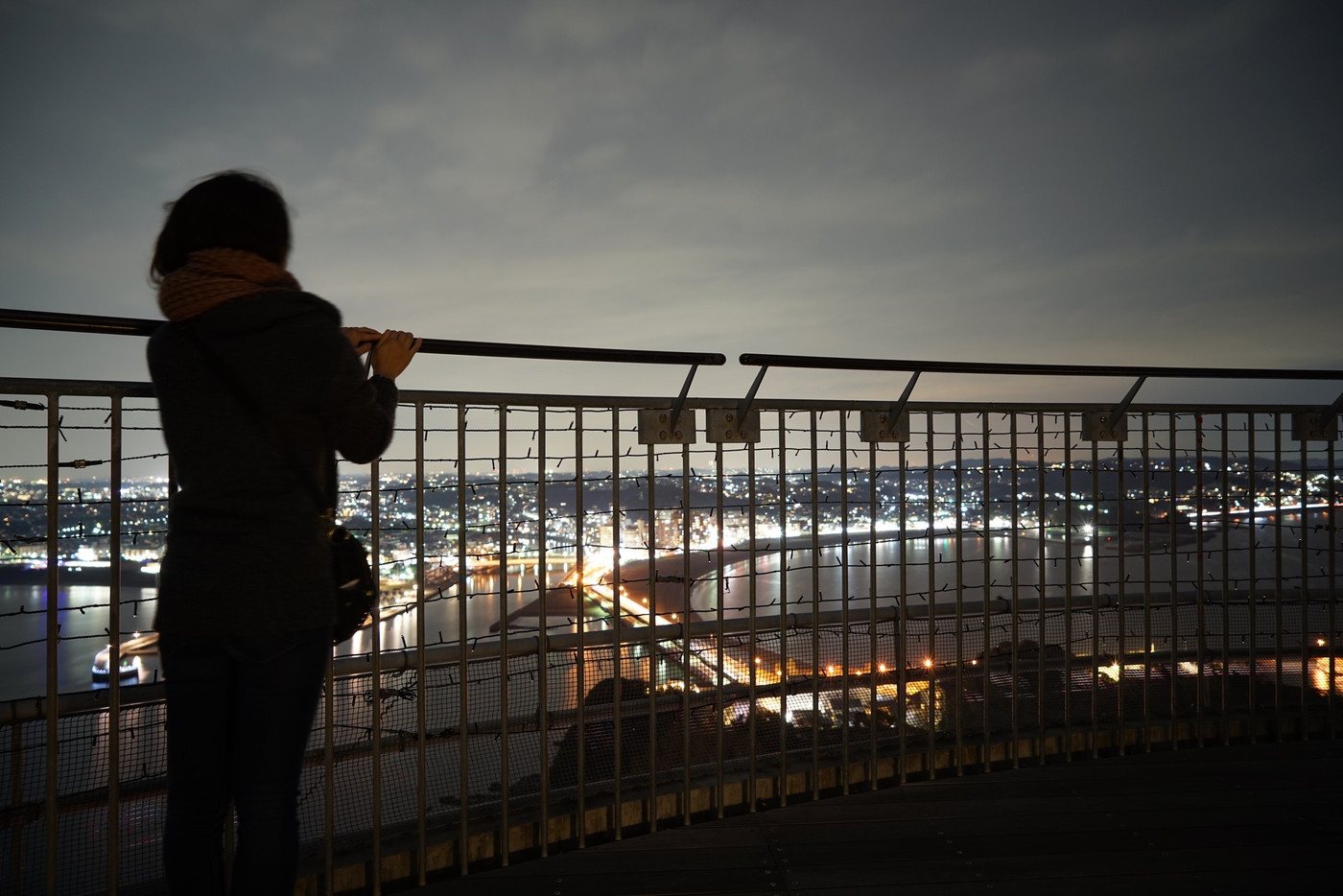 江の島シーキャンドルから夜景を見る女性のシルエット