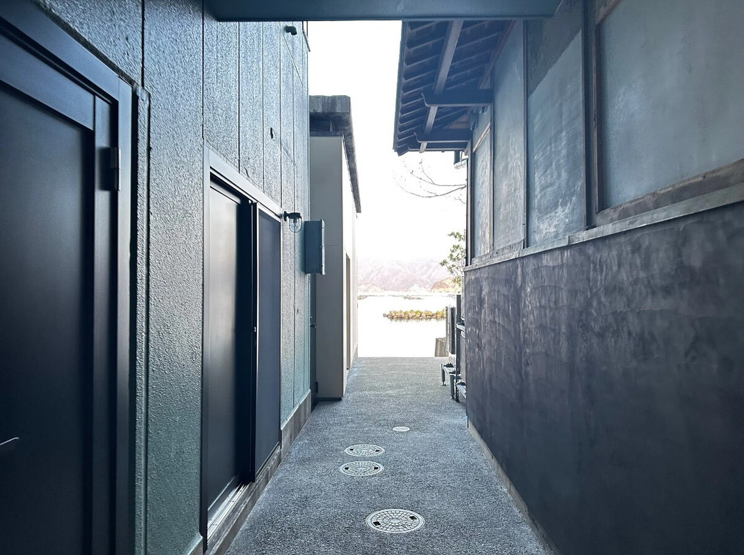 ラウンジから海岸のテラスへ抜ける道。路地裏のような雰囲気と、磯の香りにわくわく / 1