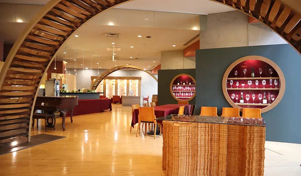 ロビー隣の「八ヶ岳ワインカーヴラウンジ」。ワイン樽をリユースしたアーチやワイングラスが並ぶ空間は、テレワークスペースとしても利用できます。