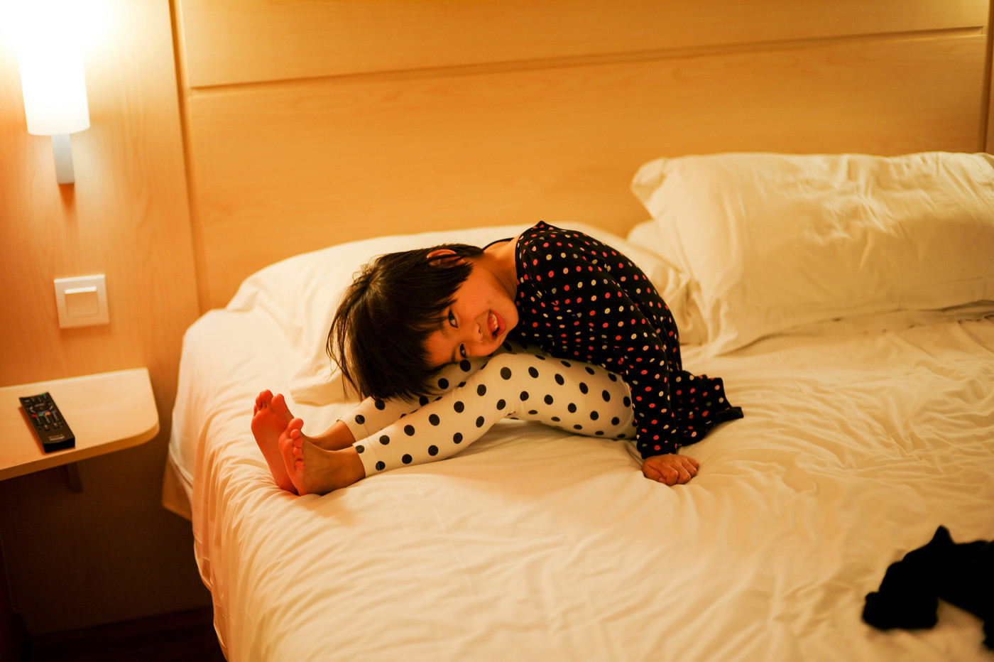 Asian little girl sits on the bed with smiling