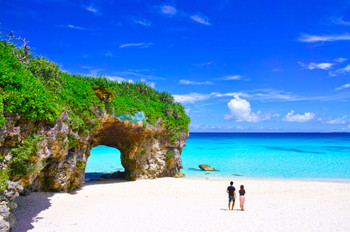 Miyakojima in midsummer. A couple looking at the sea on Sunayama beach