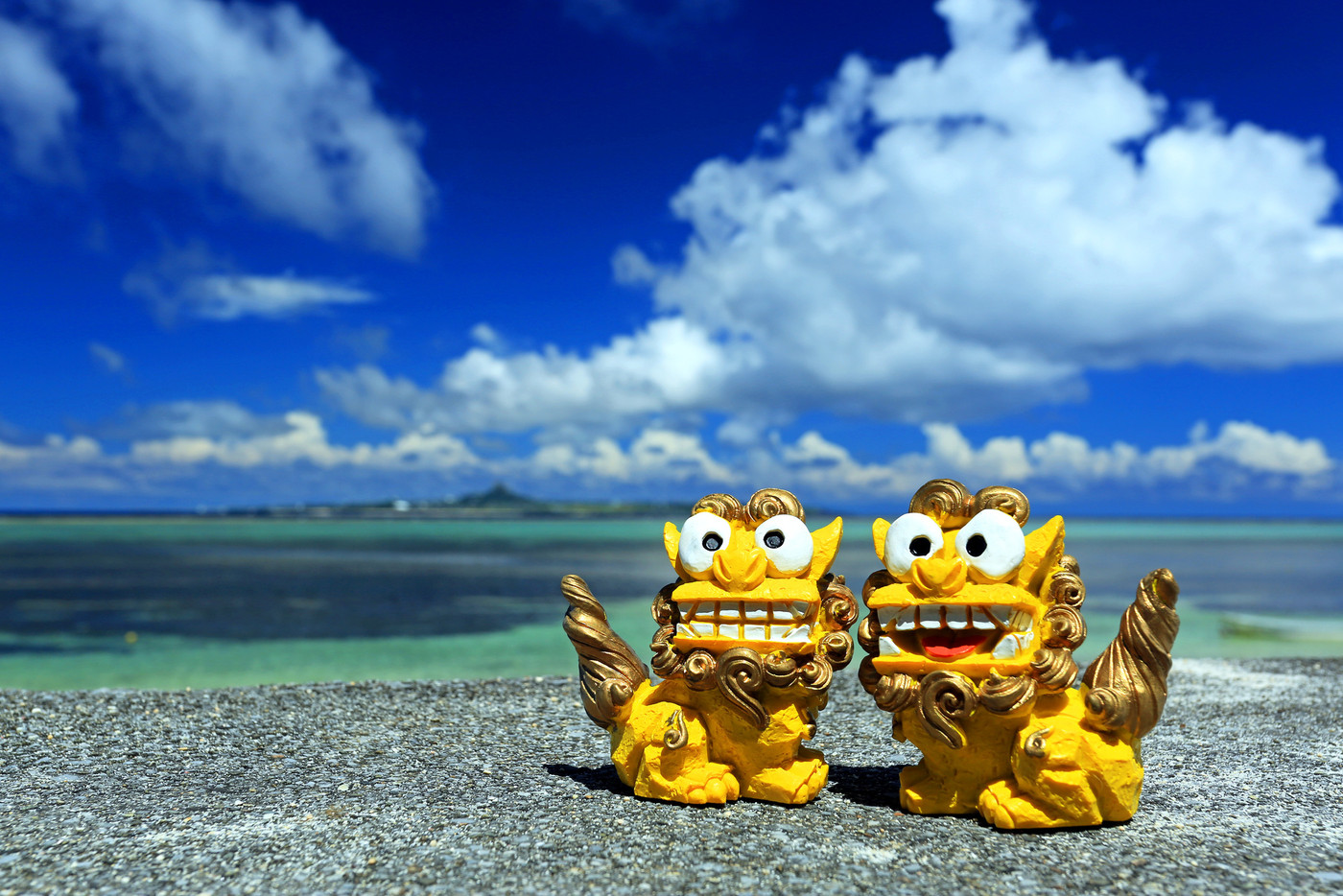 沖縄のシーサーカップル 青い海と伊江島をバックに