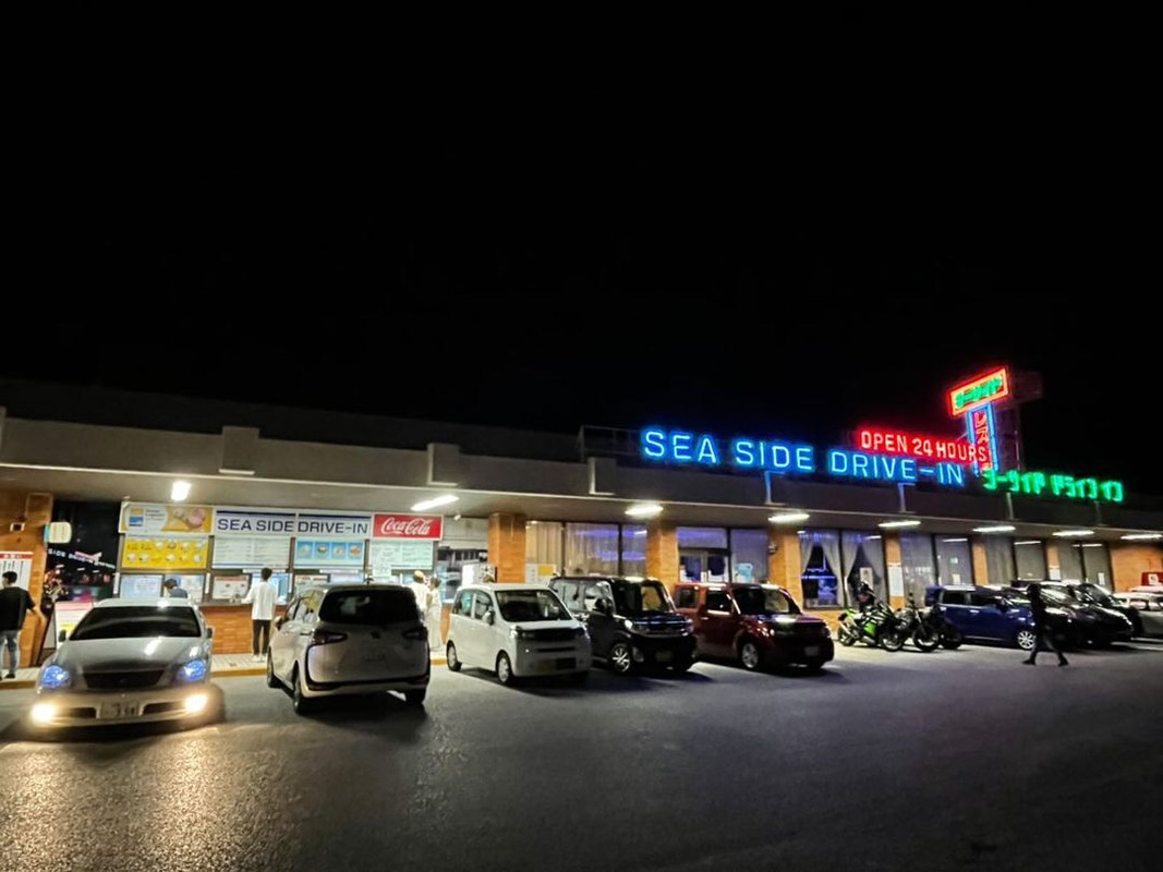 夜の「シーサイドドライブイン」の外観。店内レストランでの食事も可能 / 1