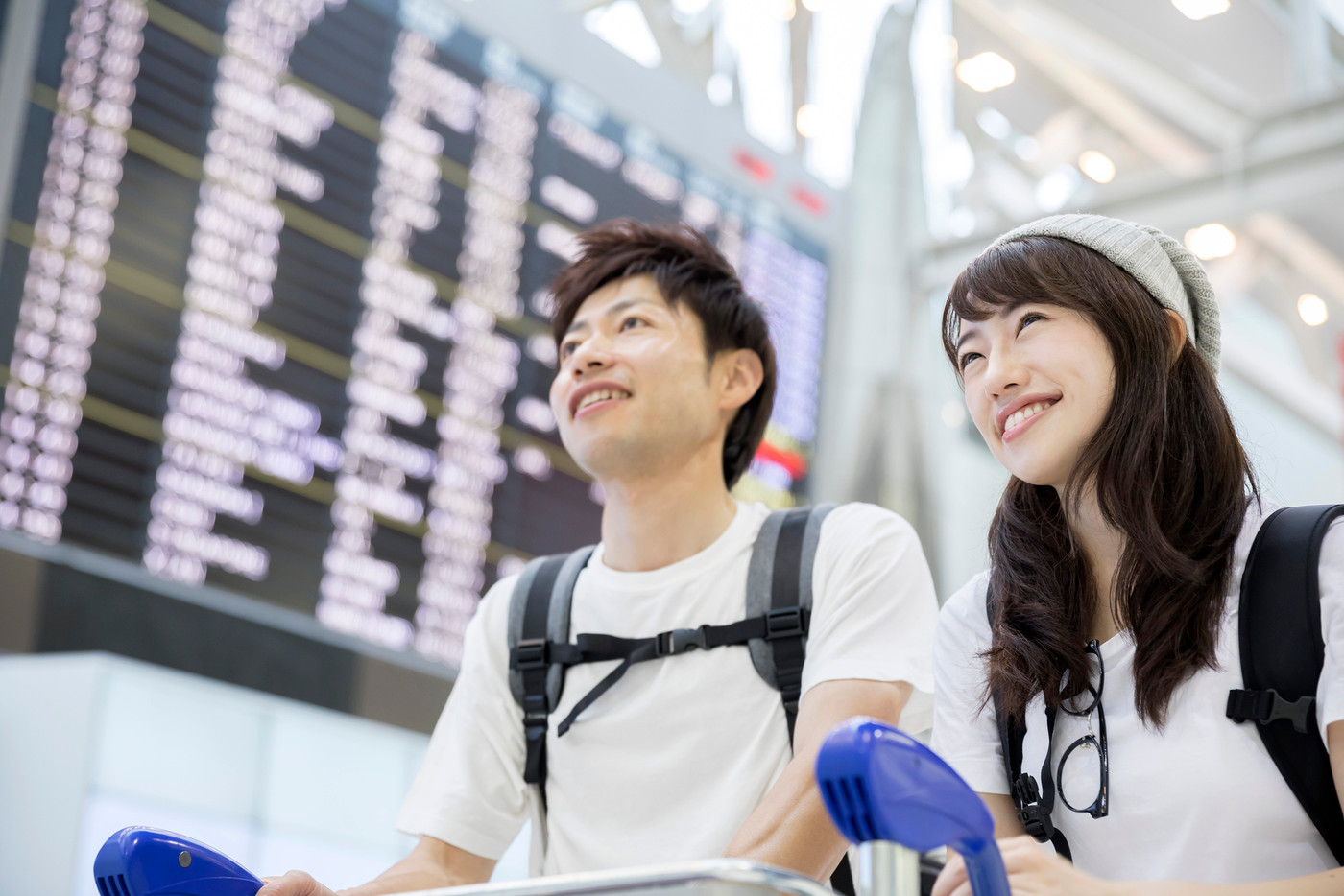 空港でカートを押すカップル 夫婦