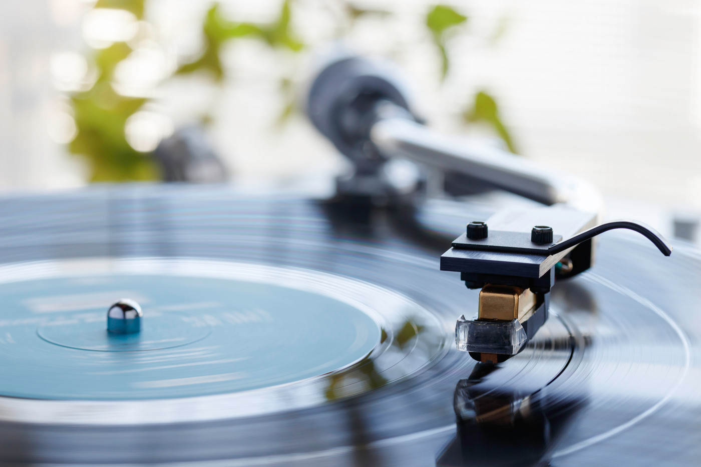 陽の射し込む窓際でレコードプレーヤーで音楽を聴く