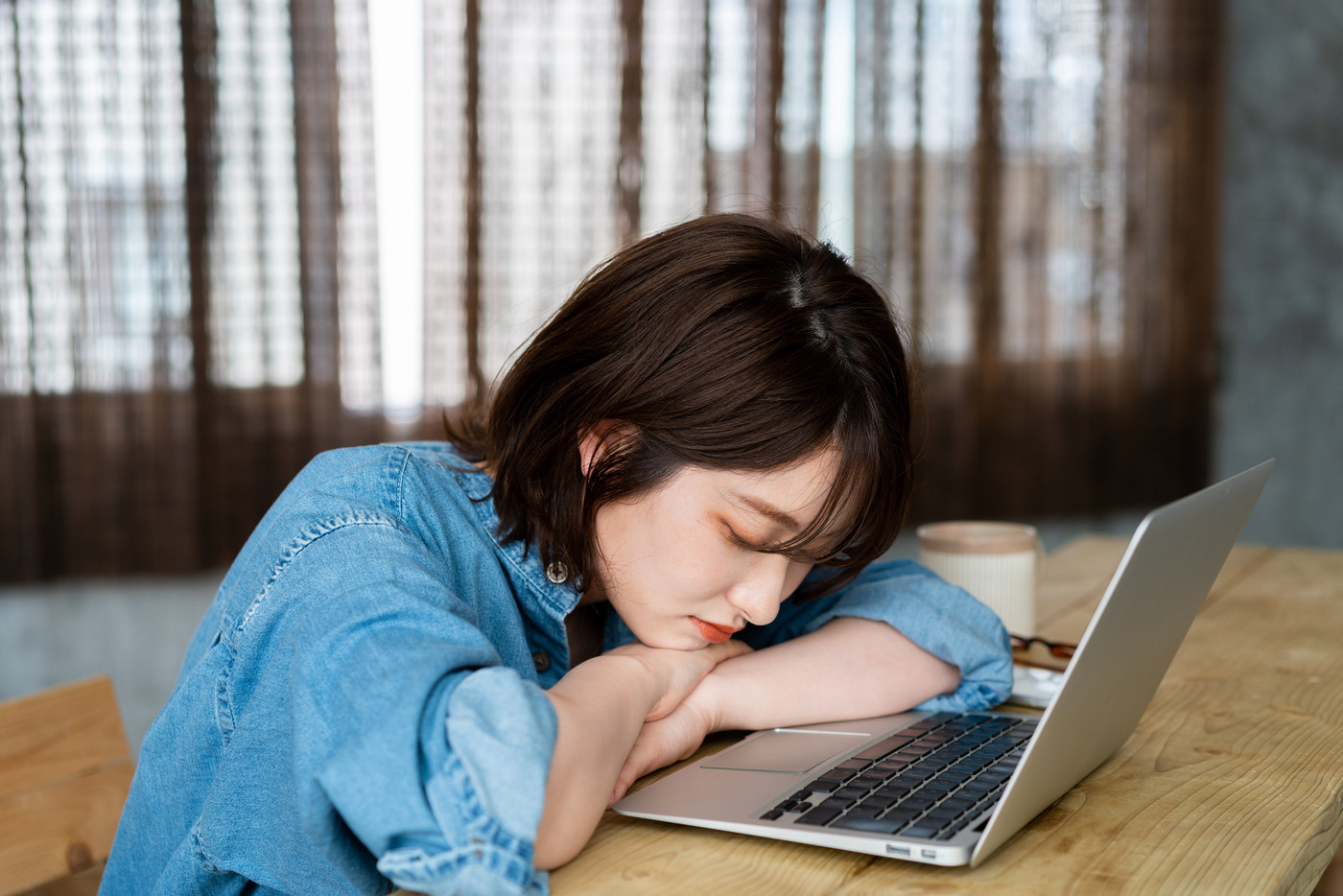 リビングでノートパソコンを使いながら寝てしまう女性