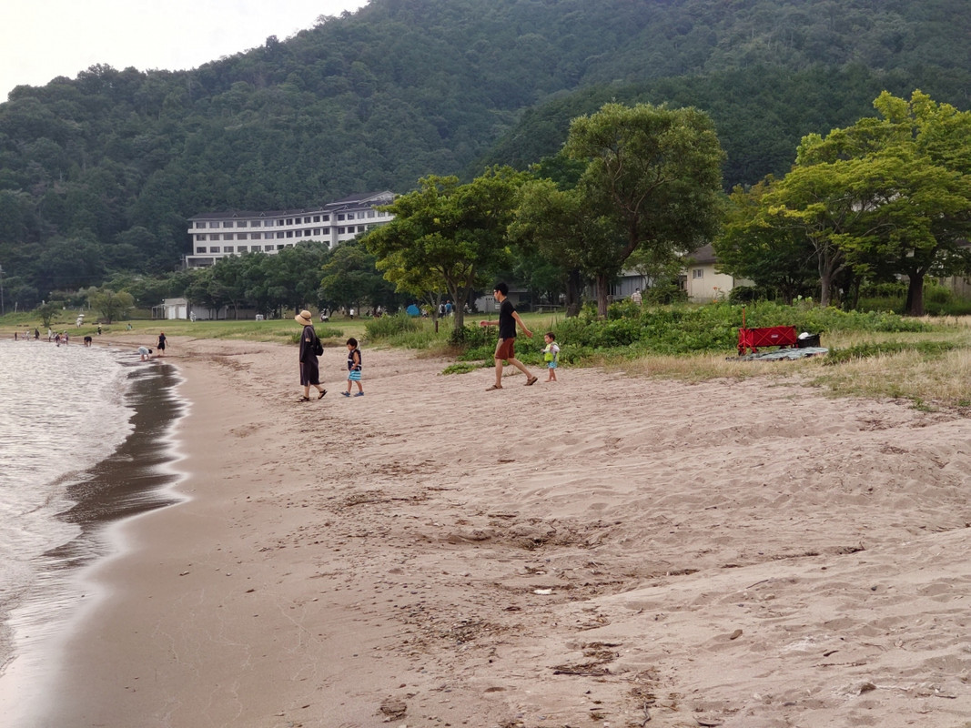 浜の向こうの高台に東館が見える。