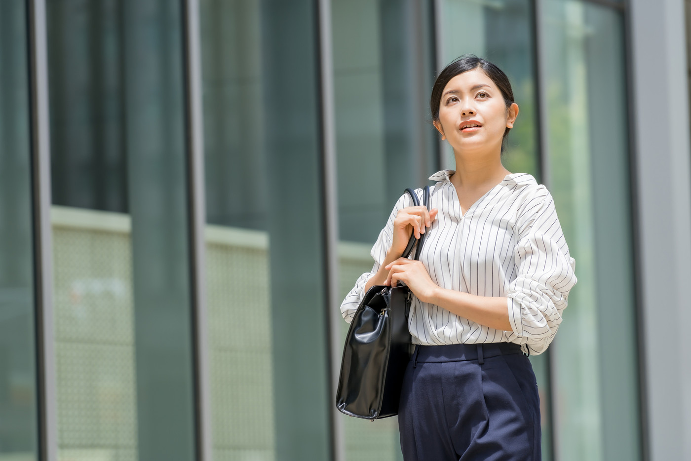 ビジネス街を歩く七分袖のビジネスウーマン