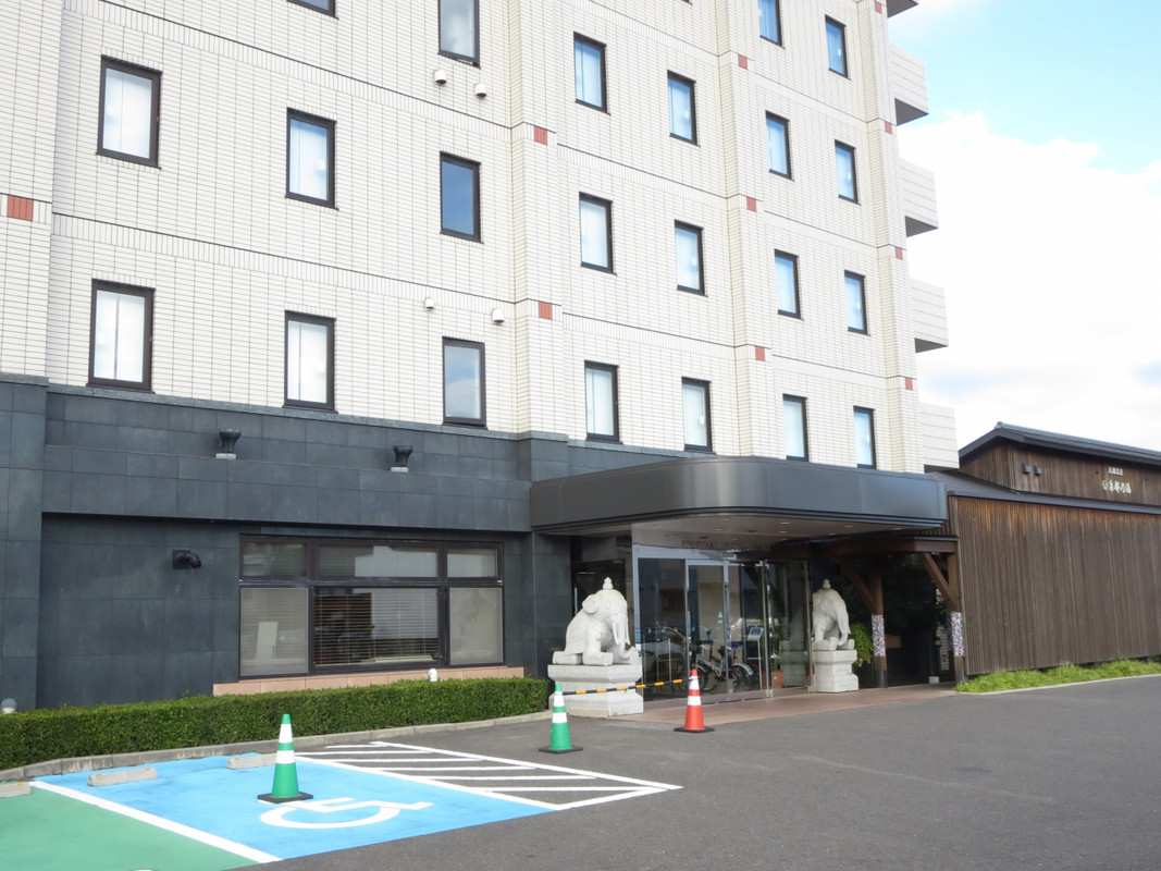 ホテル玄関、前面にある無料駐車場、奥は隣接の温泉です。