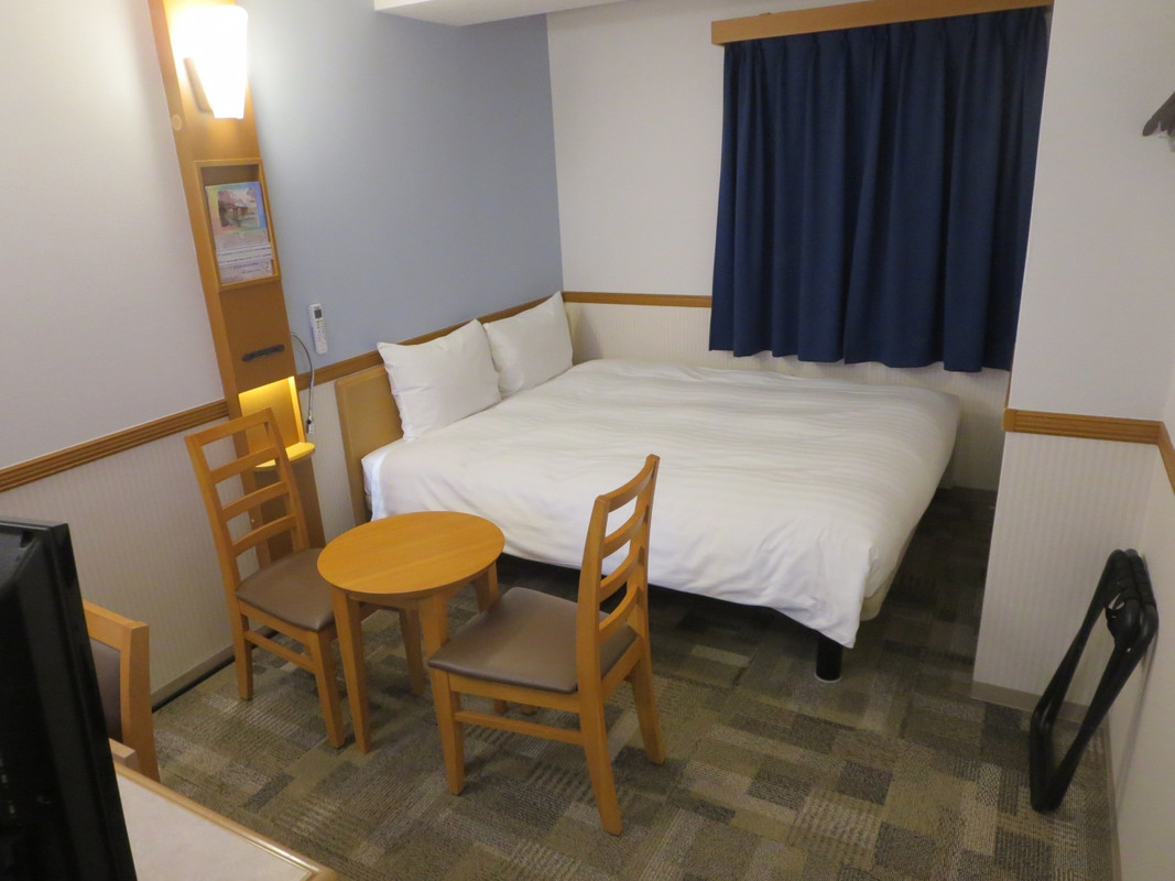 客室はかなり広くクィーンサイズベッドにテーブルがあります。