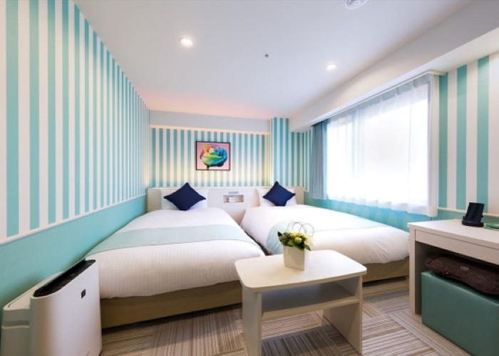 ストライプの壁紙がおしゃれな客室は、白・ピンク・ブルーを配したキュートな空間