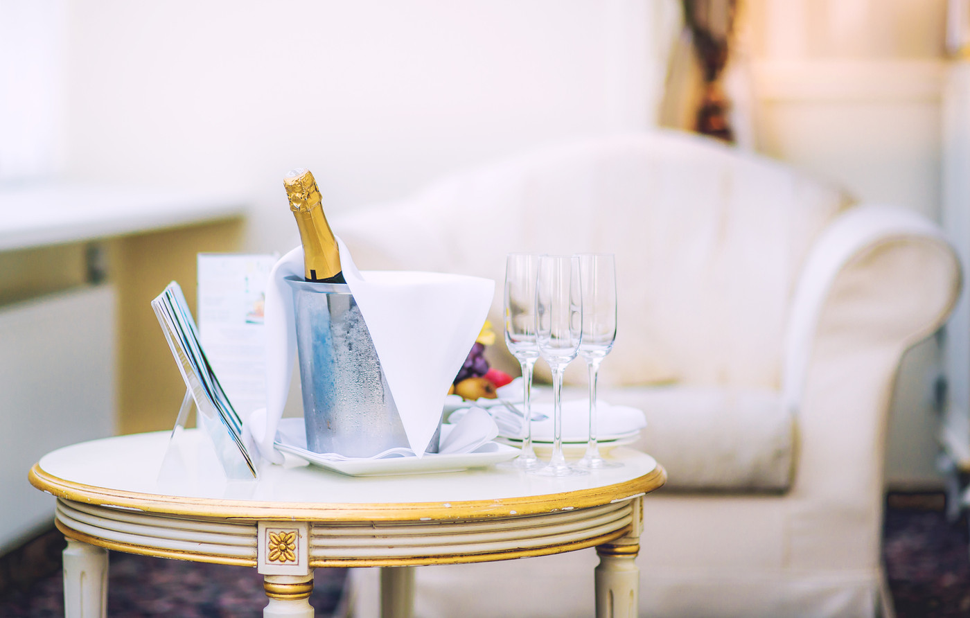 Bottle of champagne and glasses on a table in the hotel room
