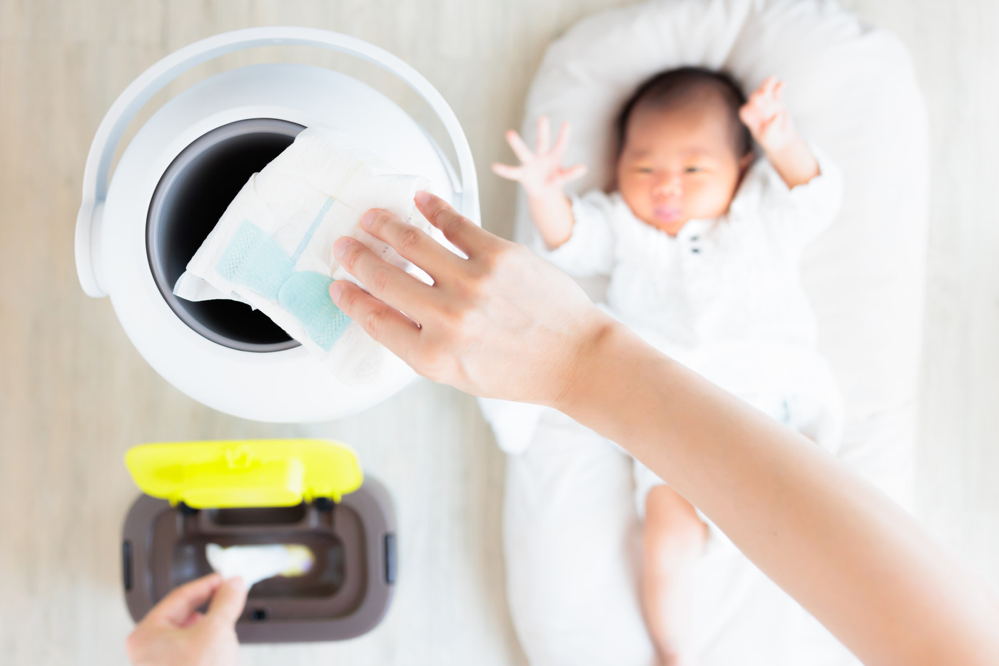 おむつ用ゴミ箱に捨てる母親の手元