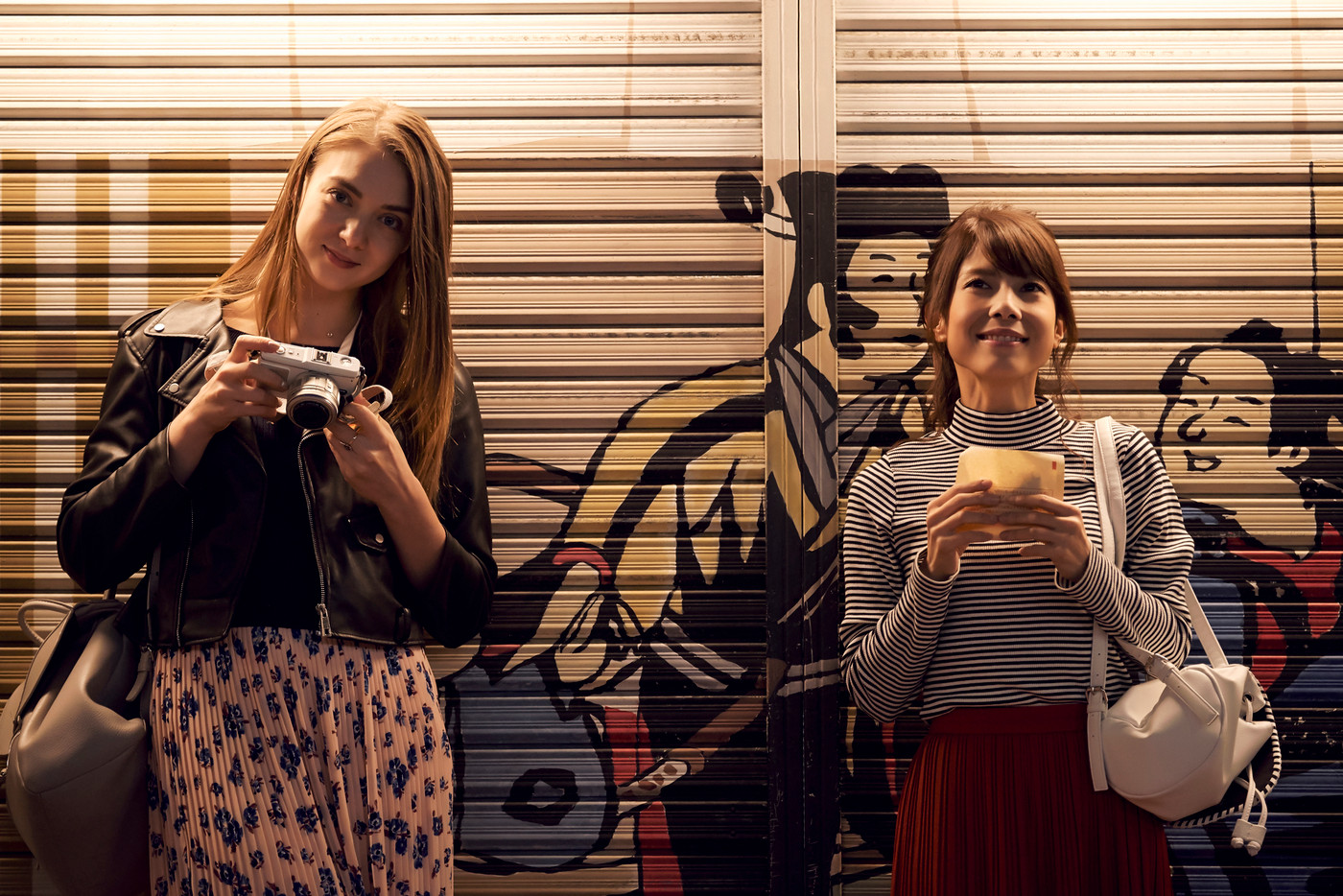 夜の東京を観光する外国人女性と日本人女性