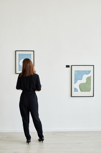 Woman Looking at Painting in Art Gallery Back View