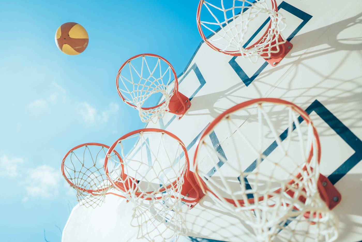 空に舞うバスケットボールと空とゴールを写して爽やかな写真に仕上げました。