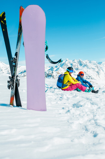 Photo of snowboard, skis on background of sitting