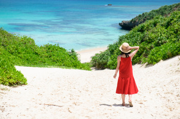 Woman walking on the road leading to the sea