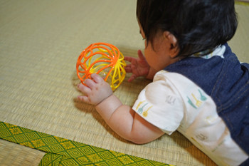 Back view of a baby playing with a toy