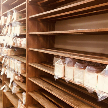 「パンのペリカン」 内観 77760067 棚に並ぶたくさんの食パン。
ほとんどが予約分。