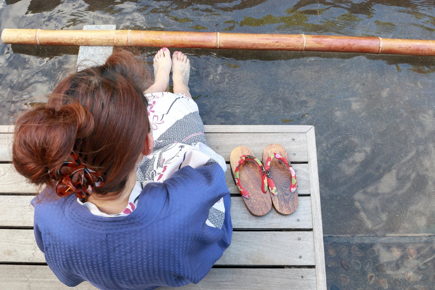銀山温泉　屋外の足湯に浸かる若い女性